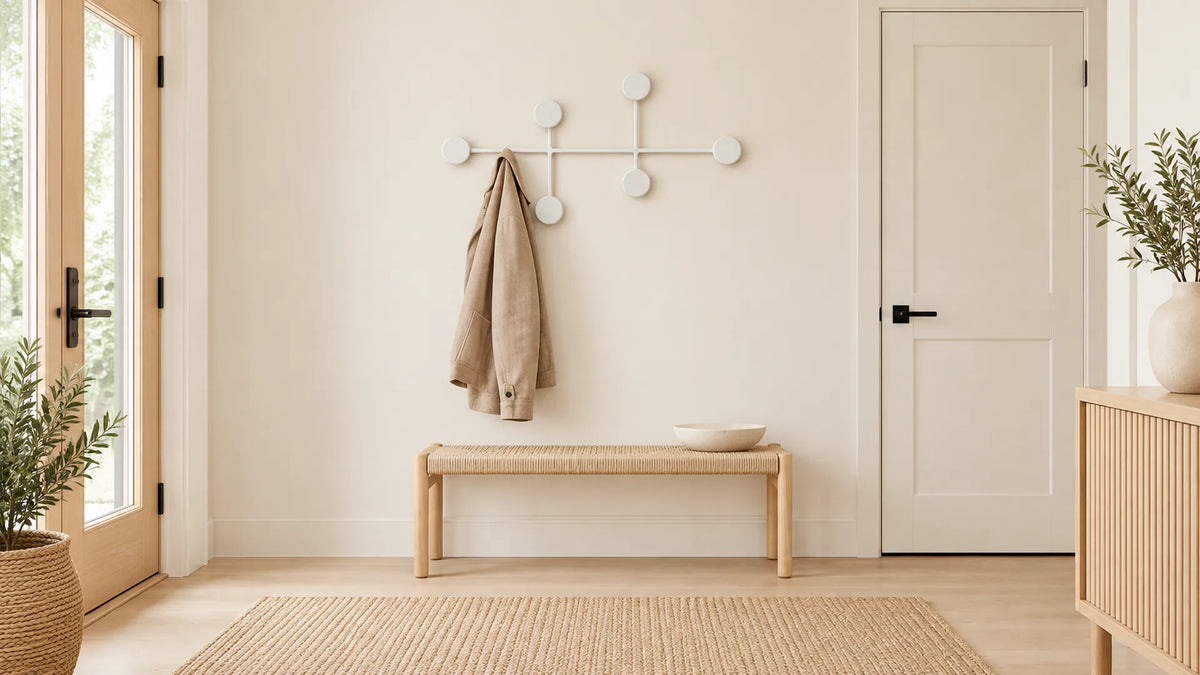 Entrée scandinave associant bois clair, mur blanc et six disques blancs