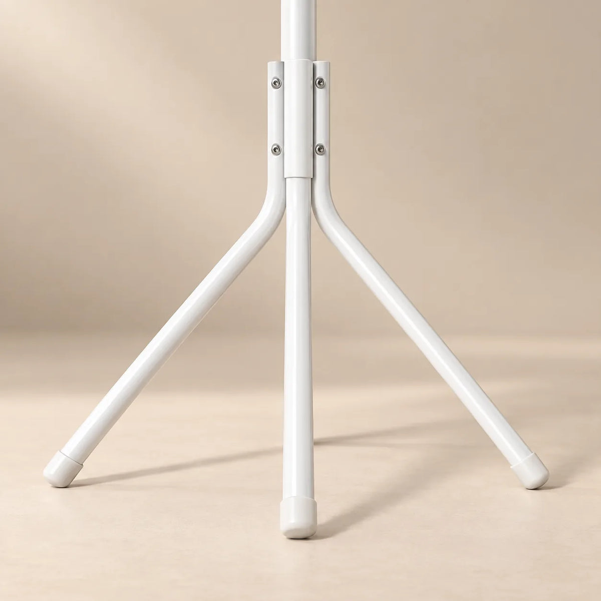 Détail de la base trépied et des pieds antidérapants du porte-manteau blanc