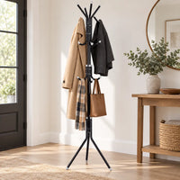Porte-manteau sur pied noir utilisé avec manteaux, écharpe et sac dans une entrée