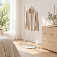 Porte-manteau valet blanc avec chemise en lin dans une chambre lumineuse