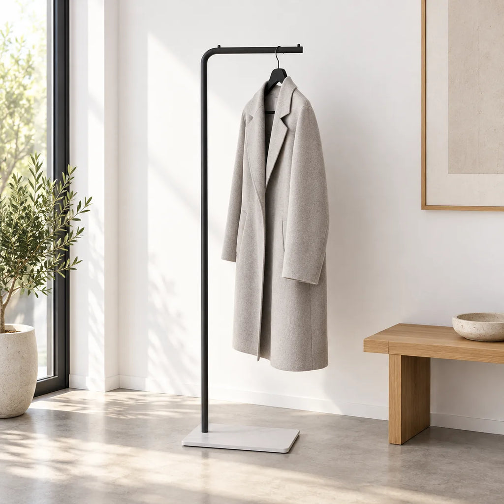 Porte-manteau valet noir avec manteau gris dans une entrée minimaliste