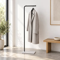 Porte-manteau valet noir avec manteau gris dans une entrée minimaliste