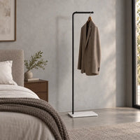 Porte-manteau valet noir avec veste taupe dans une chambre contemporaine