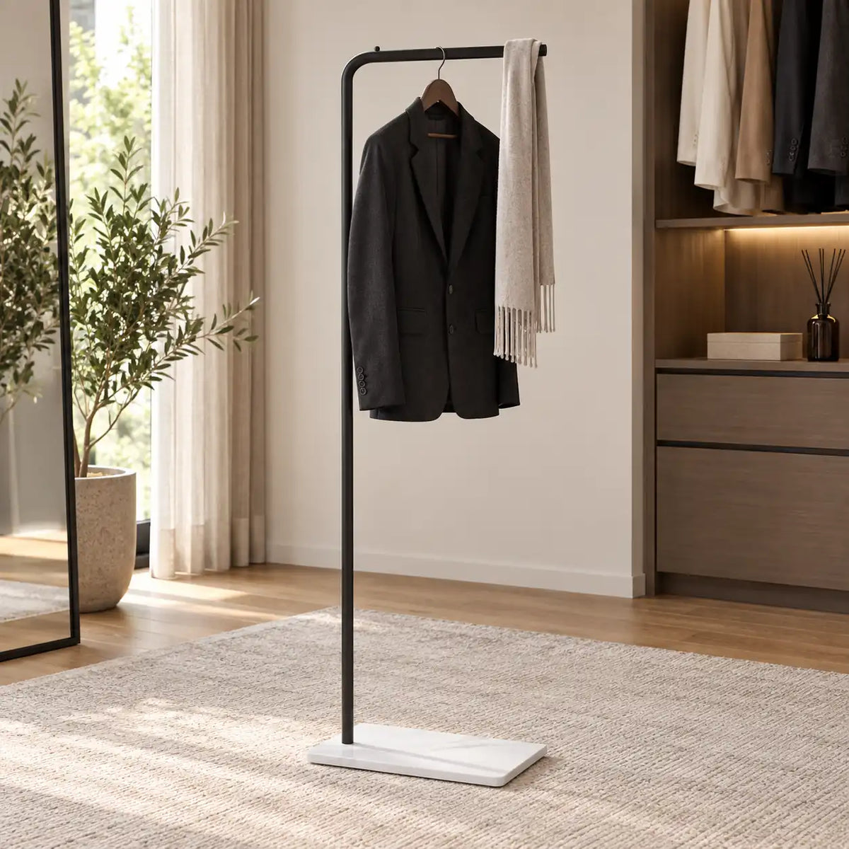 Porte-manteau valet noir utilisé avec veste sombre et écharpe dans un dressing