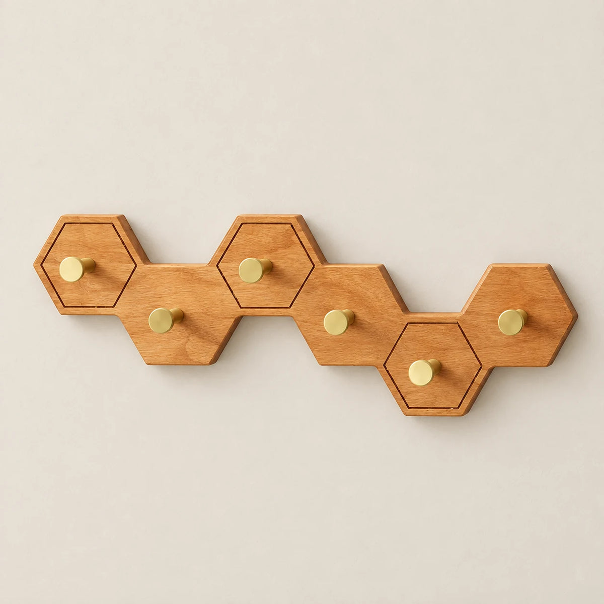 Crochet mural nid d’abeille bois clair, 6 crochets en laiton, vue de face sur fond beige