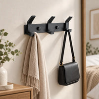 Crochet mural noir aluminium 3 crochets — dans une chambre avec accessoires suspendus