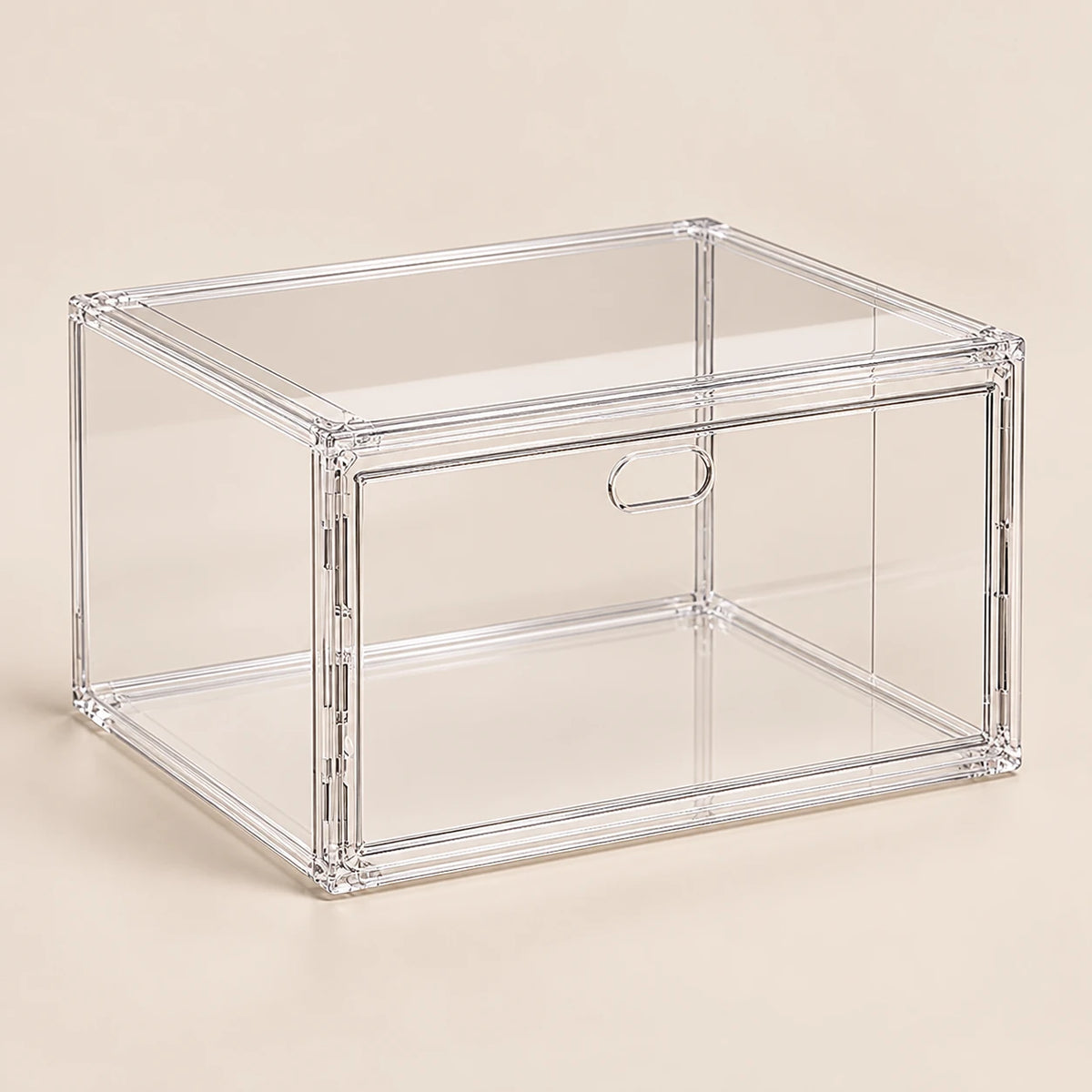 Boîte à chaussures transparente avec porte latérale magnétique sur fond beige.