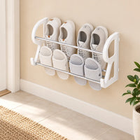 Petit rangement chaussures blanc avec baskets et chaussons sur un mur beige.