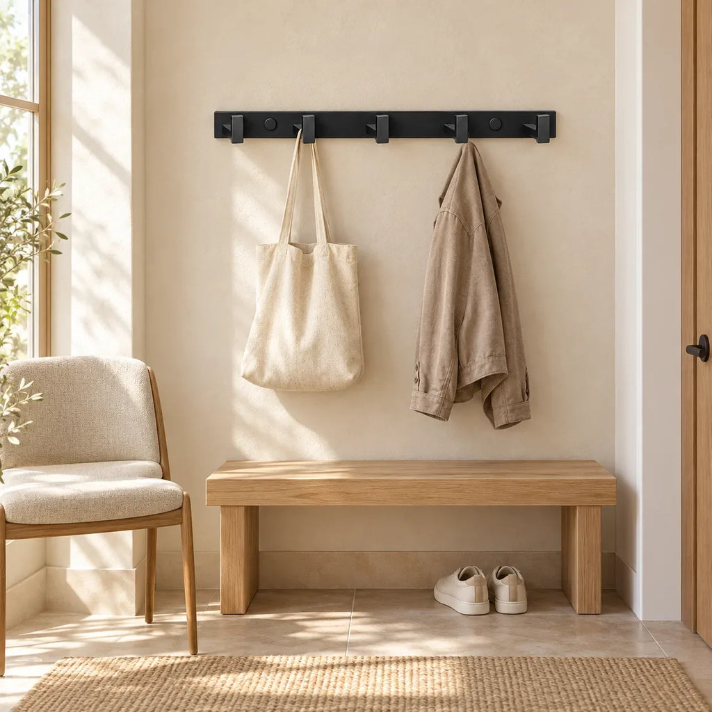 Support noir à 5 crochets avec veste sèche et sac suspendus dans une entrée claire
