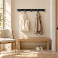 Support noir à 5 crochets avec veste sèche et sac suspendus dans une entrée claire
