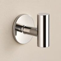 Patère design chrome brillant en inox adhésive : détail de la base ronde fixée au mur