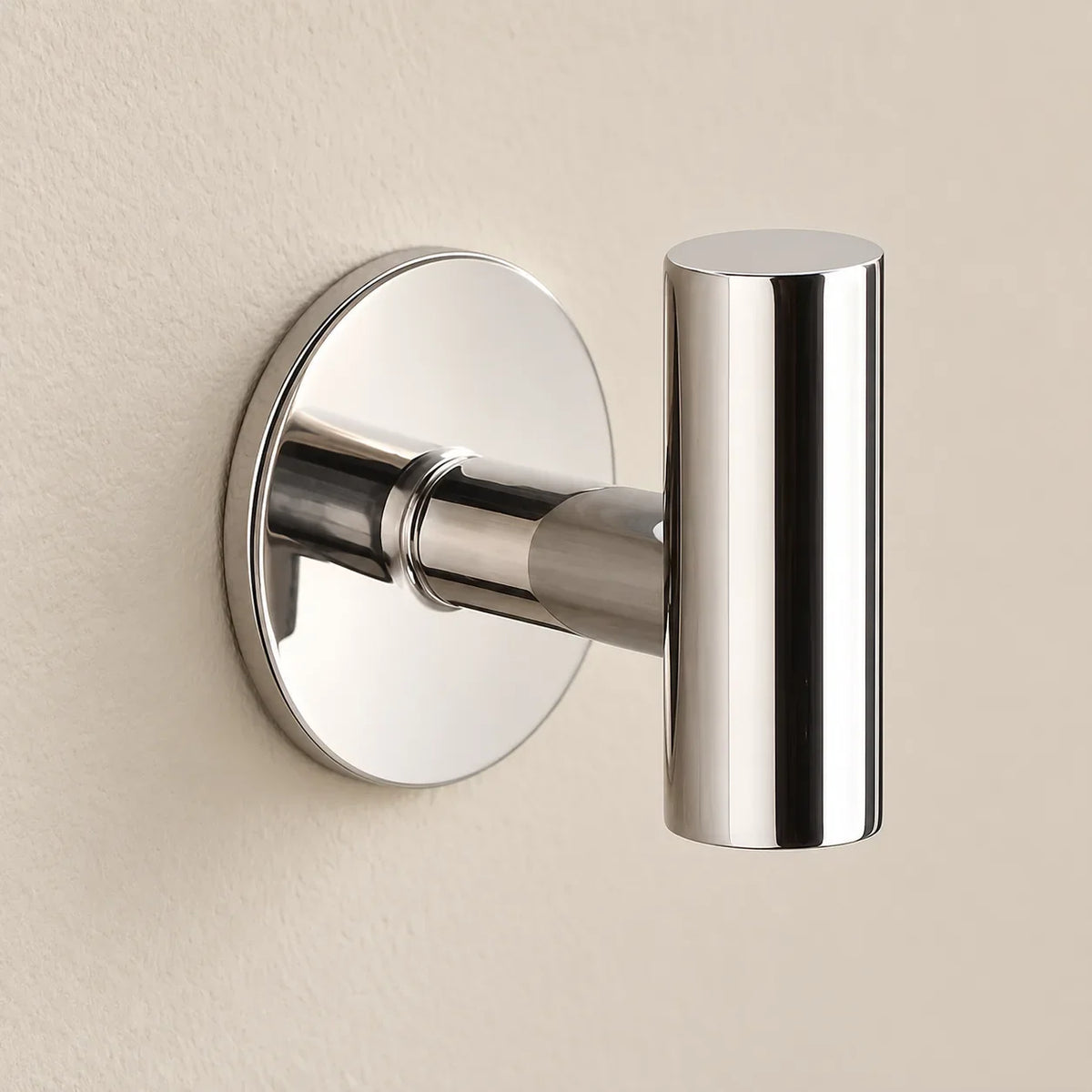 Patère design chrome brillant en inox adhésive : détail de la base ronde fixée au mur