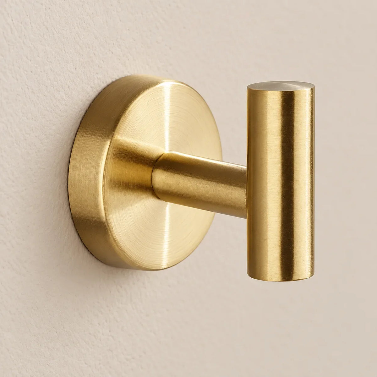 Patère design dorée en inox à vis : détail de la base ronde fixée au mur