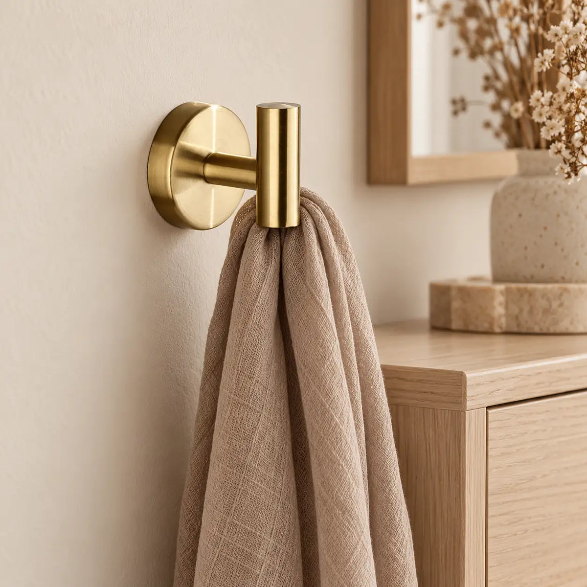 Patère design dorée en inox à vis : écharpe près d’un meuble
