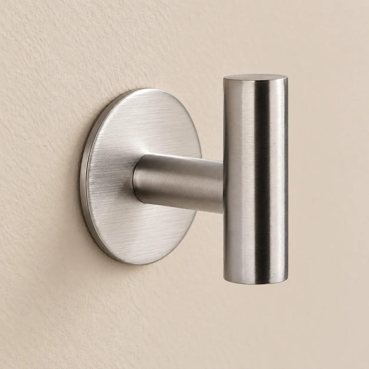 Patère design inox brossé en inox adhésive : détail de la base ronde fixée au mur