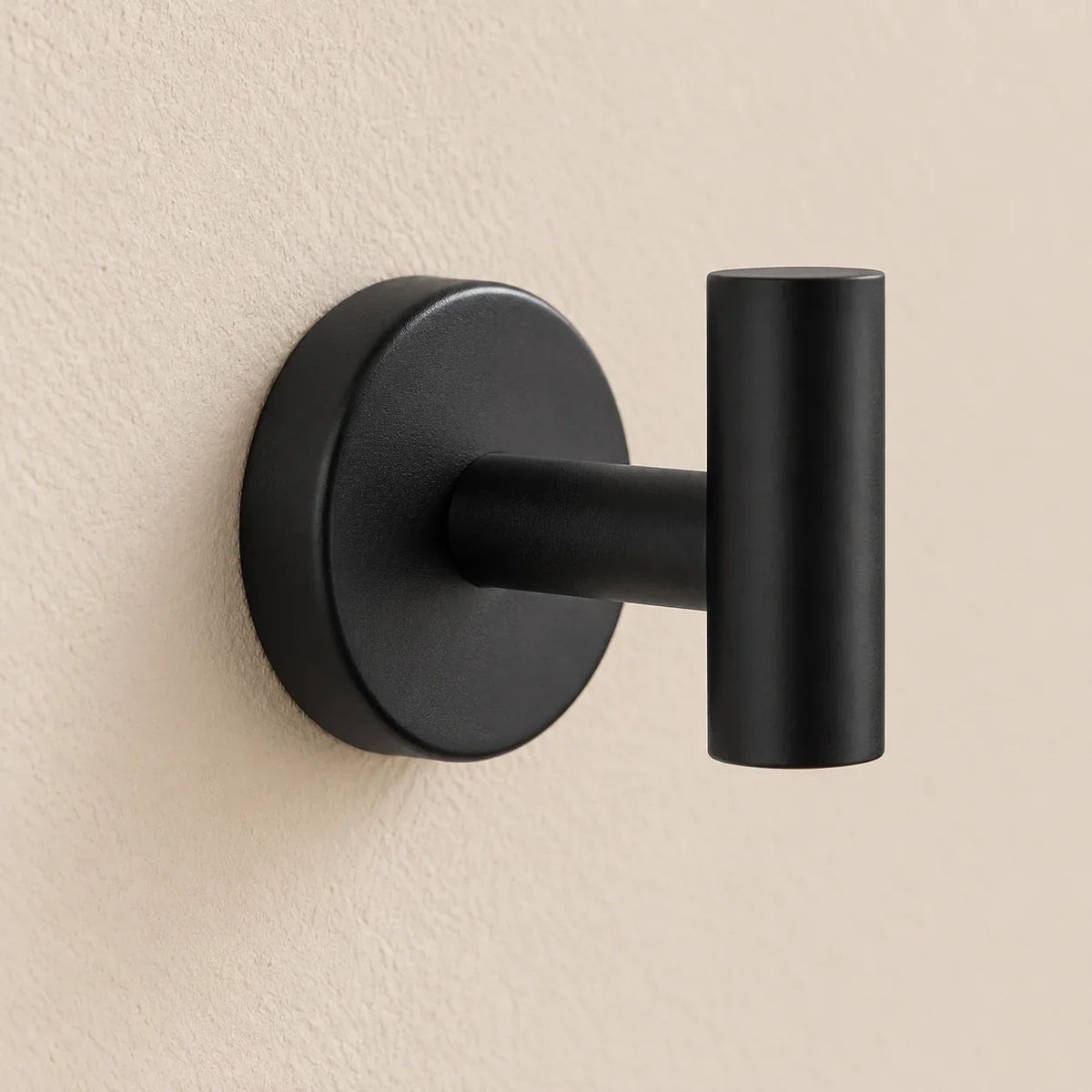 Patère design noire en inox à vis : détail de la base ronde fixée au mur