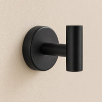 Patère design noire en inox à vis : détail de la base ronde fixée au mur