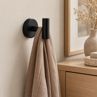 Patère design noire en inox à vis : écharpe près d’un meuble