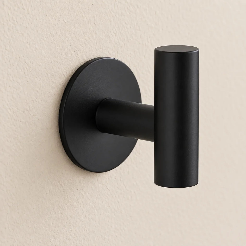 Patère design noire en inox adhésive : détail de la base ronde fixée au mur