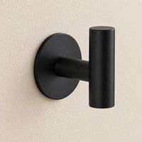 Patère design noire en inox adhésive : détail de la base ronde fixée au mur