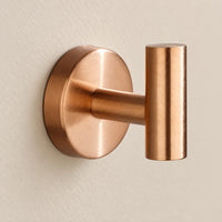 Patère design or rose en inox à vis : détail de la base ronde fixée au mur