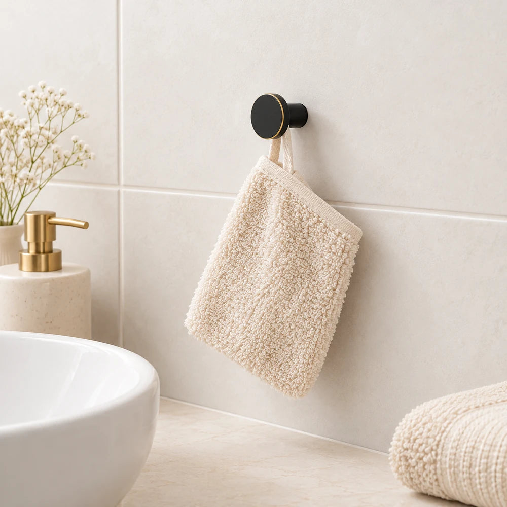 Patère laiton noir et liseré doré ronde 20 mm : illustration avec un gant de toilette