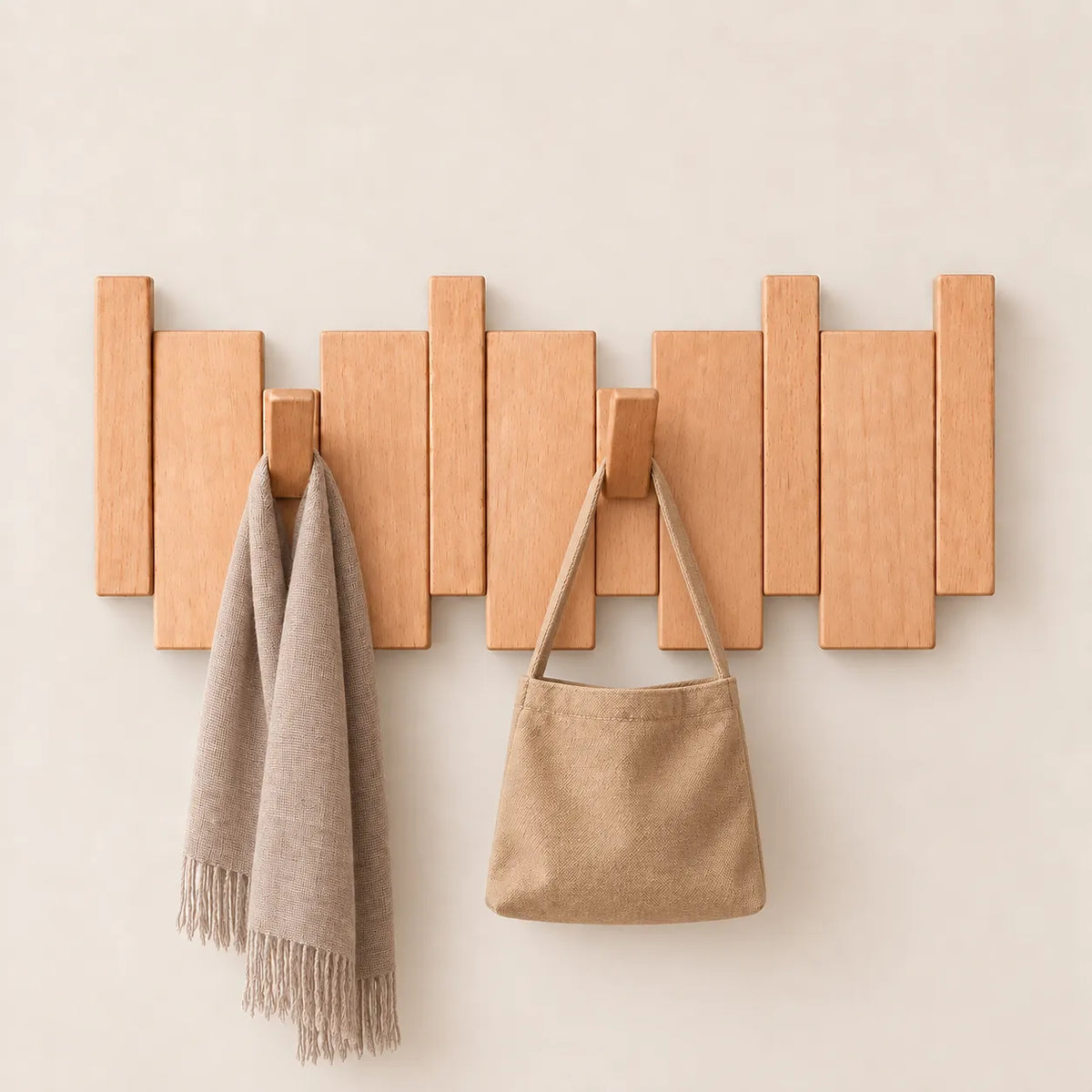 Patère murale en hêtre naturel clair, 4 crochets, avec sac et écharpe.