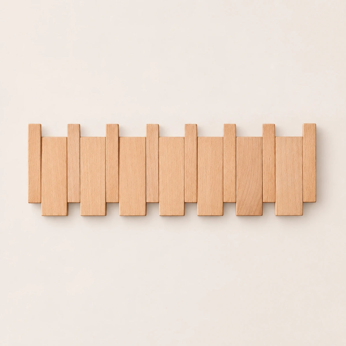 Patère murale en hêtre naturel clair, modèle 6 crochets piano, sur fond beige.