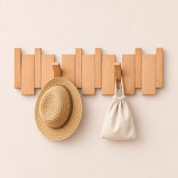 Patère hêtre naturel clair 6 crochets avec chapeau et petit accessoire suspendus.