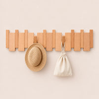 Patère hêtre naturel clair 8 crochets avec chapeau et petit accessoire suspendus.
