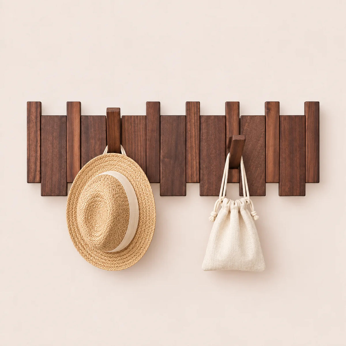 Patère noyer foncé 6 crochets avec chapeau et petit accessoire suspendus.
