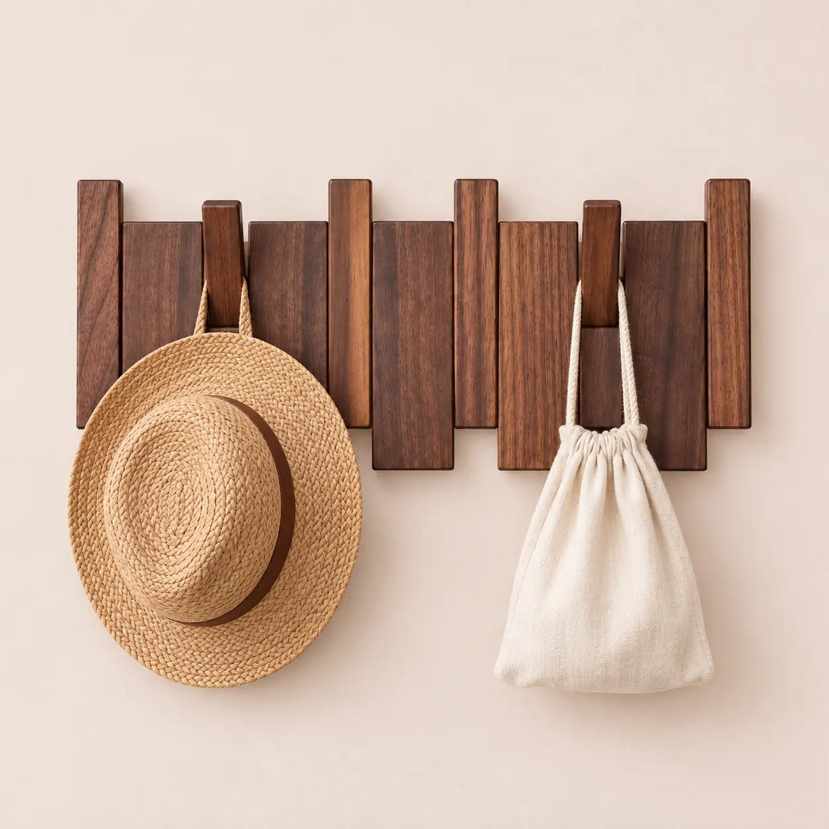 Patère noyer foncé 4 crochets avec chapeau et petit accessoire suspendus.